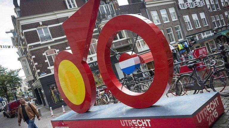 A man walks past a giant imitation bicycle, painted red, as Utrecht prepares to host the Tour de France