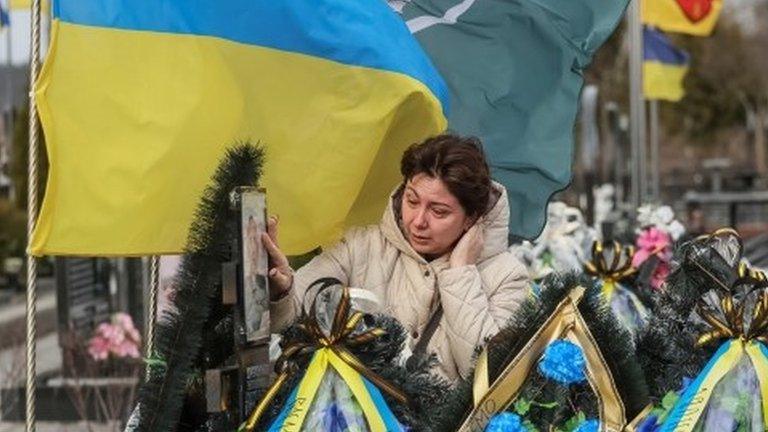 Woman visits grave of relative in Bucha, Ukraine