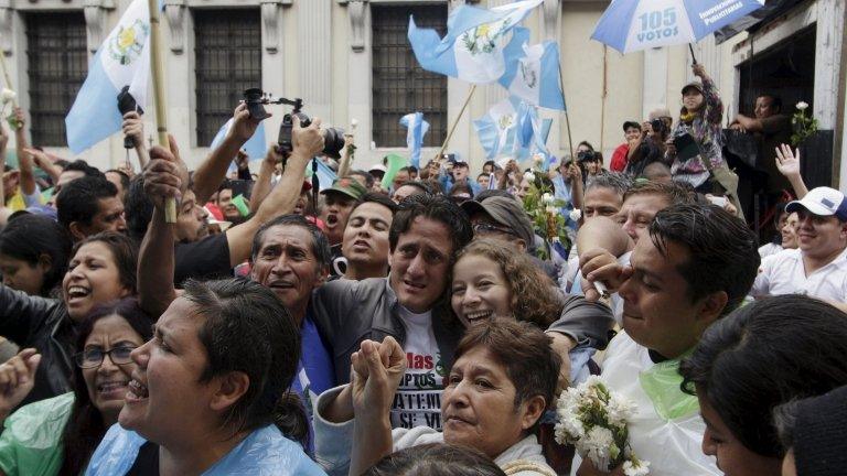 People react outside of the Guatemalan Congress building after the congress voted to strip President Otto Perez of immunity, in Guatemala City, September 1, 2015.