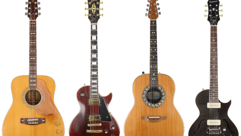 Four guitars lined up on a white background - two acoustic, two electric. Two light wood, two darker.