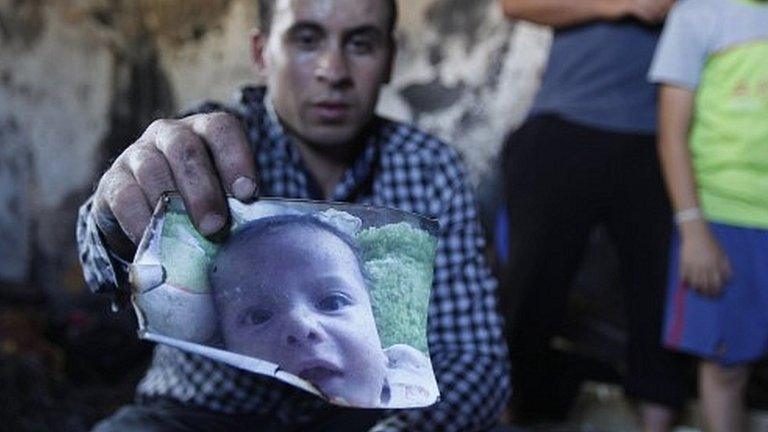 Palestinian holds scorched photo of Ali Saad Dawabsha (31/07/15)