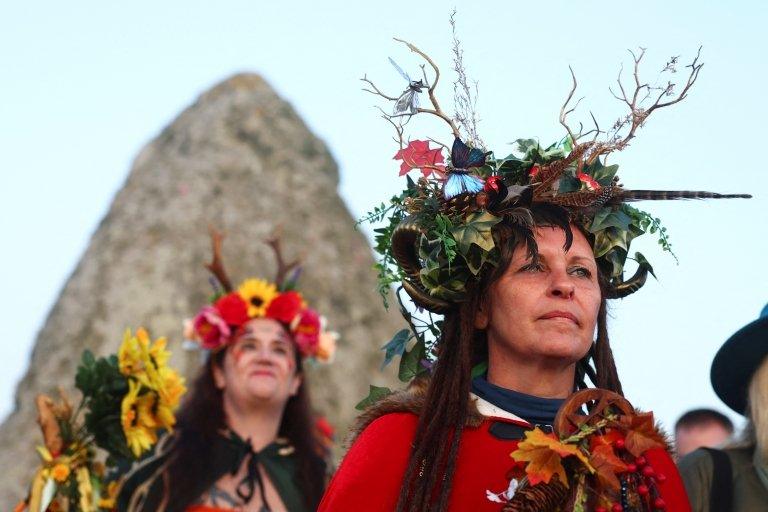 women in headdresses near to Stonehenge