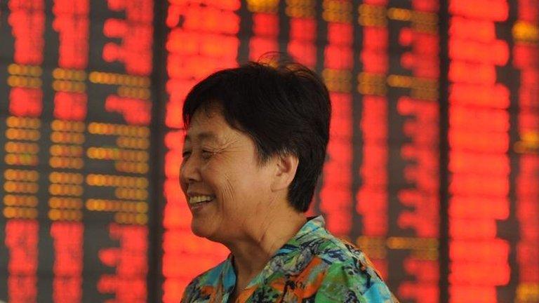 Woman in front of Chinese share board