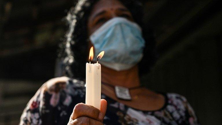 A woman holds a candle