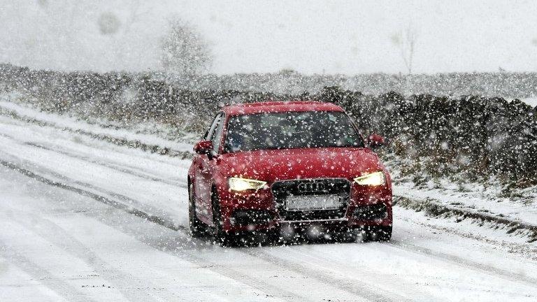 Car driving through the snow in the Peak District