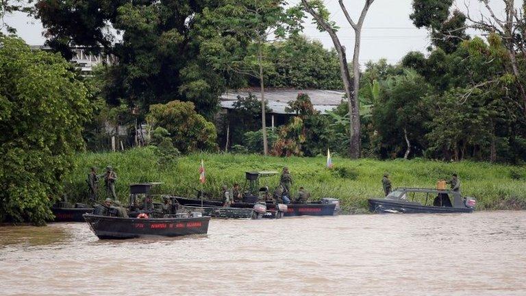 Venezuelan soldiers patrol by boat on the Arauca River, the border between Colombia and Venezuela, as seen from Arauquita, Colombia, March 28, 2021.