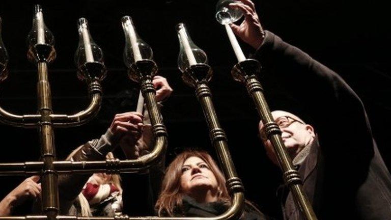 A man lights a chanukiah to celebrate Hanukkah in Istanbul, Turkey, 13 December 2015