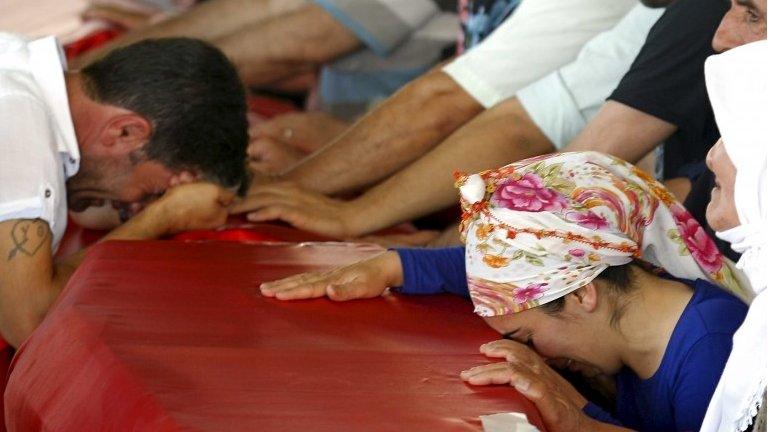 Relatives of victims who were killed in Monday"s bomb attack in Suruc mourn over the coffins at a cemetery in Gaziantep, Turkey, July 21, 2015