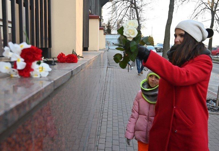 Woman lays flowers outside the Canadian embassy in Kiev