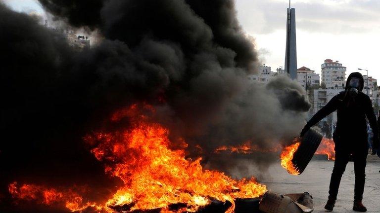 A Palestinian protester burns tyres during clashes with Israeli troops near the West Bank city of Ramallah. Photo: 7 December 2017