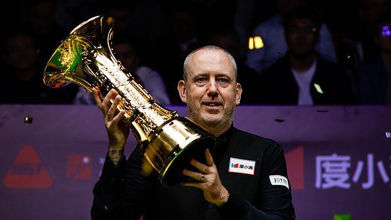 Mark Williams celebrates with the trophy