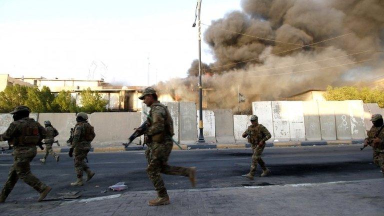 Smoke rises from a government building in Basra, Iraq