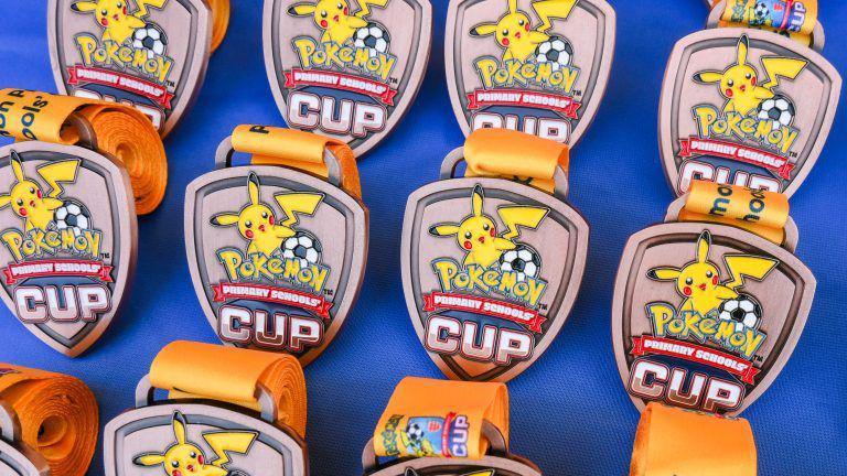 A photo of the Pokemon Primary Schools' Cup medals.