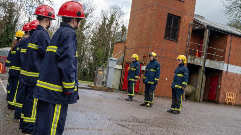 Children being drilled by firefighters