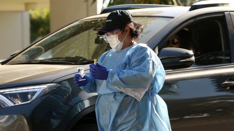 A medical worker takes samples at a clinic in Australia