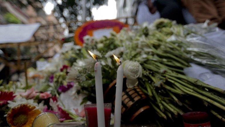 People offer flowers and light candles to pay their respects to the victims of the attack on Holey Artisan Bakery, in Dhaka, Bangladesh, Tuesday, July 5, 2016.