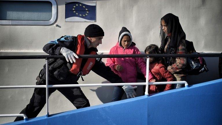 A coastguard helps migrants disembark from a Bulgarian patrol ship at the port in Mytilene, Greece. Photo: 18 February 2016