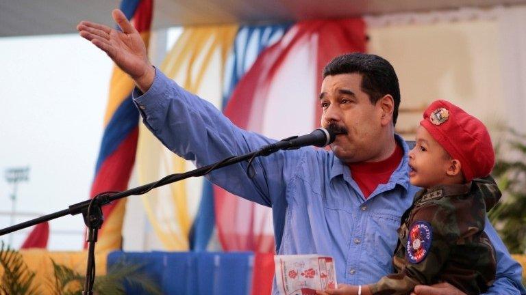 Venezuela's President Nicolas Maduro carries a child wearing a costume of Venezuelan soldier, while he speaks during meeting with fishermen and entrepreneurs in the fisheries sector in Guanta at the Anzoategui state, Venezuela May 18, 2016.