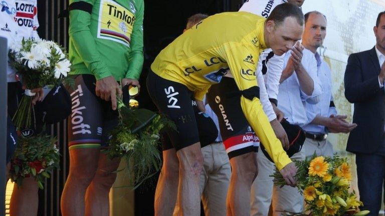 Chris Froome lays flowers while observing a minute's silence for the Nice attack