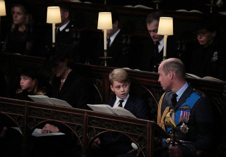 Princess Charlotte, the Princess of Wales, Prince George, and the Prince of Wales, watch as the Imperial State Crown and the Sovereign"s orb and sceptre are removed from the coffin of Queen Elizabeth II, draped in the Royal Standard, during the Committal Service at St George"s Chapel in Windsor Castle, Berkshire