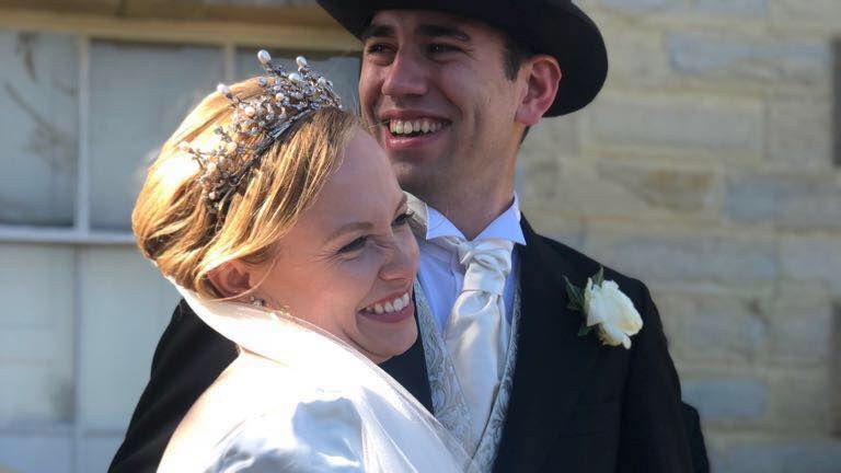 The Earl of Yarmouth, wearing a black suit with a golden tie and top hat next to his wife wearing a tiara and a white dress