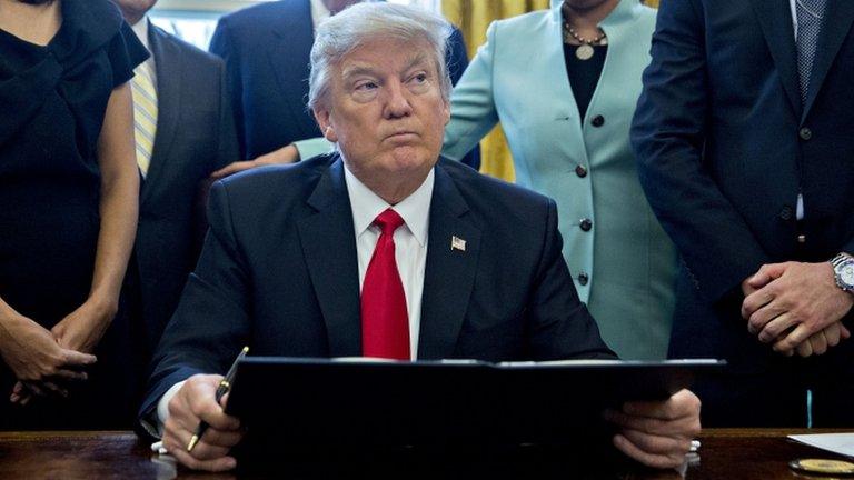 President Donald Trump pauses after signing an executive order in the Oval Office of the White House