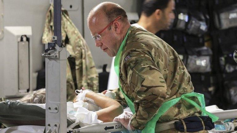 A military medic attends a women patient