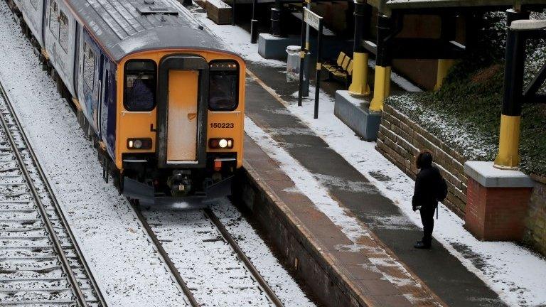 A train on snow covered tracks at Hunts Cross Station, Merseyside