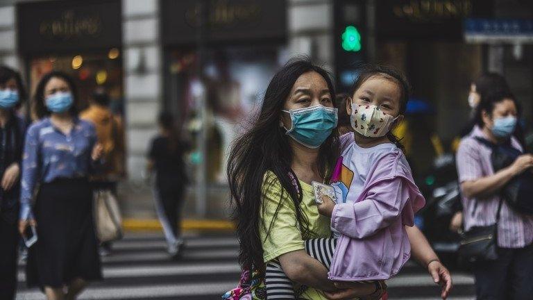 People cross the street in Shanghai, China, 11 May 2021