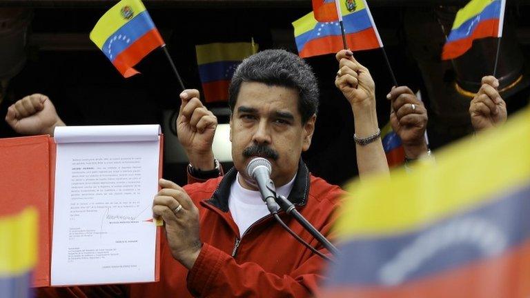 Venezuela's President Nicolas Maduro shows a document with the details of a "constituent assembly" to reform the constitution during a rally at Miraflores Palace in Caracas, Venezuela May 23, 2017.