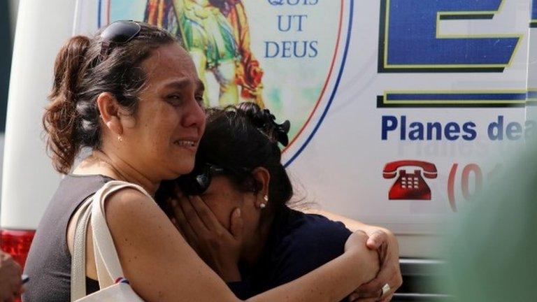 Relatives of the victims of a bus that crashed with a truck and careened off a cliff along a sharply curving highway north of Lima, wait outside a hospital morgue in Chancay, Peru, January 3, 2018