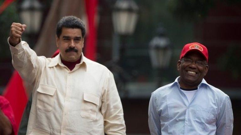 President Nicolas Maduro holds out his right fist while standing next to Vice President Aristobulo Isturiz during a ceremony marking the 206th anniversary of the call for independence from Spain, in Caracas, Venezuela, Tuesday, April 19, 2016