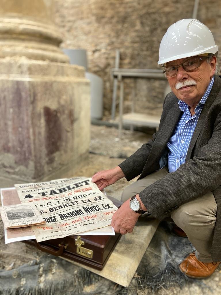 A man crouched over some papers