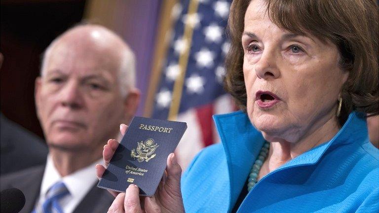 Senate Intelligence Committee Vice Chair Sen Dianne Feinstein, joined by Sen Ben Cardin, points to the embedded chip in her passport that contains digital information at a news conference in Washington on 19 November