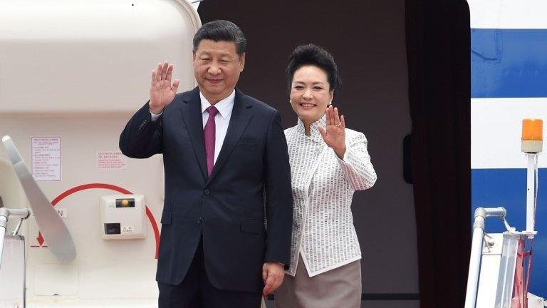 China's President Xi Jinping (L) and his wife Peng Liyuan wave upon their arrival at Hong Kong"s international airport on 29 June 2017