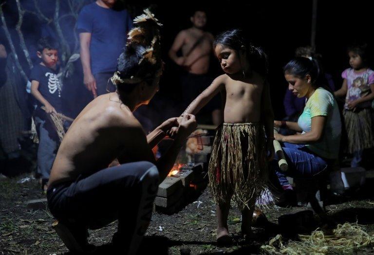 Ezaltino Juvei, 27, paints Xokleng traditional patterns on Rosa Kamam Pripra, 5, during a reunion at Xokleng Laklano Indigenous Land, Jose Boiteux, Santa Catarina state, Brazil, August 17, 2021.