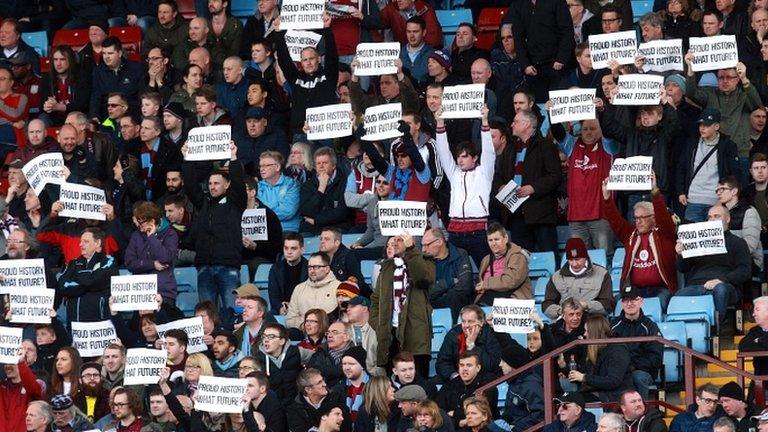 Villa fans stand to protest in the 74th minute