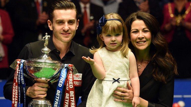 Mark Selby poses for a photograph with the trophy, his daughter Sofia Maria and wife Vikki