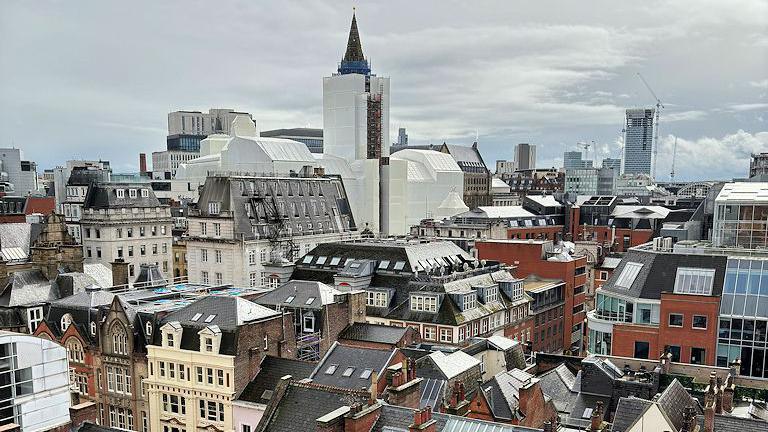 A view from the top of St Ann's church tower, looking south-eastwards over the city centre rooftops, towards Manchester Town Hall.