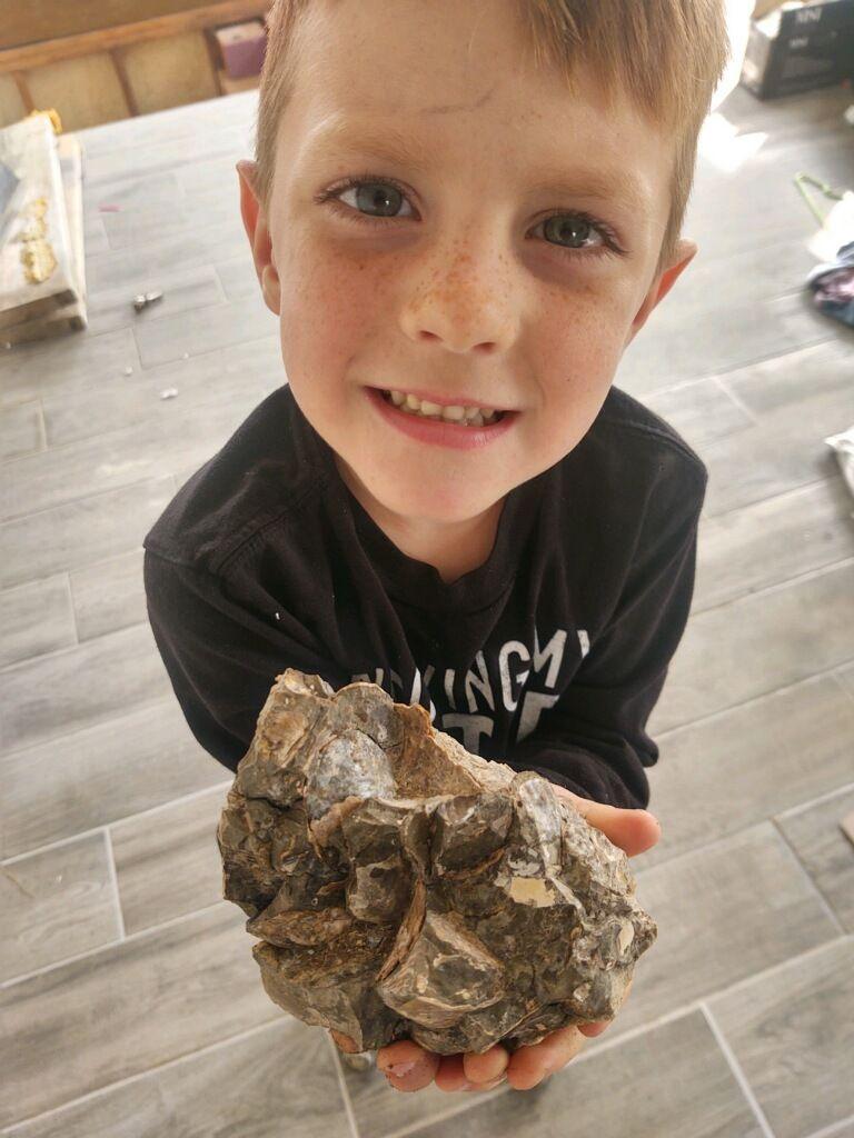 Liam holds a fossil discovery