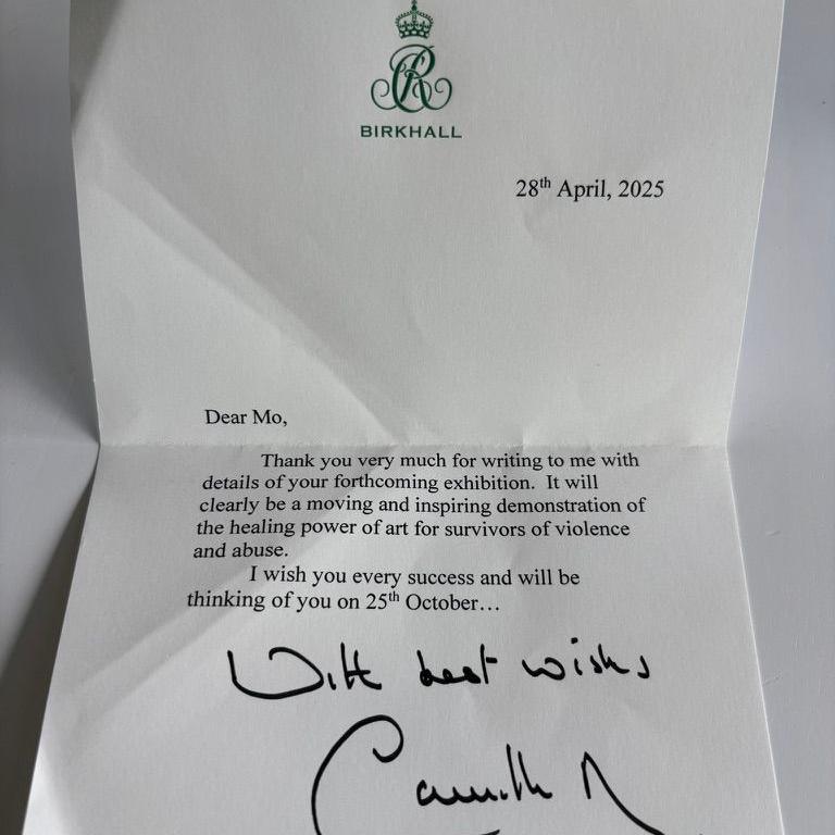 A photo of a letter from Queen Camilla addressed to someone called Mo and wishing her success with her art exhibition saying it will "clearly be a moving and inspiring demonstration of the healing power of art for survivors of violence and abuse".