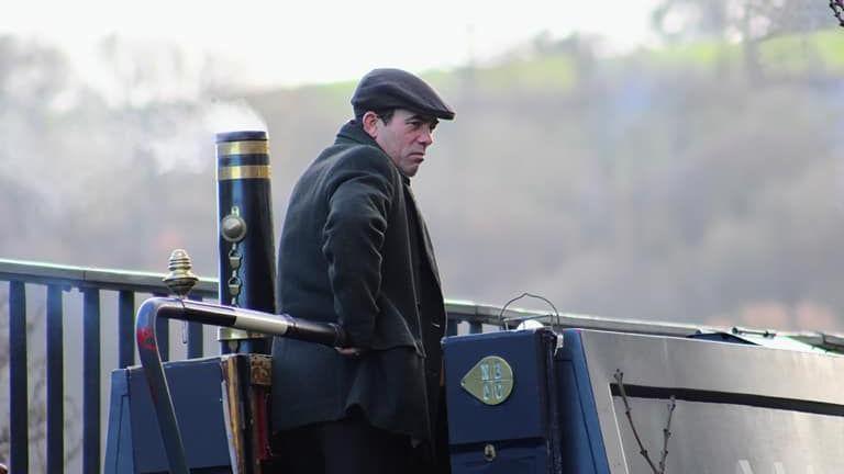 Packy Lee as Johnny Doggs, steering a narrowboat in the Peaky Blinders movie.