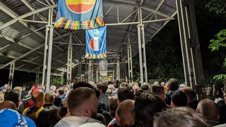 Fans queue for a tram after the England v Serbia match