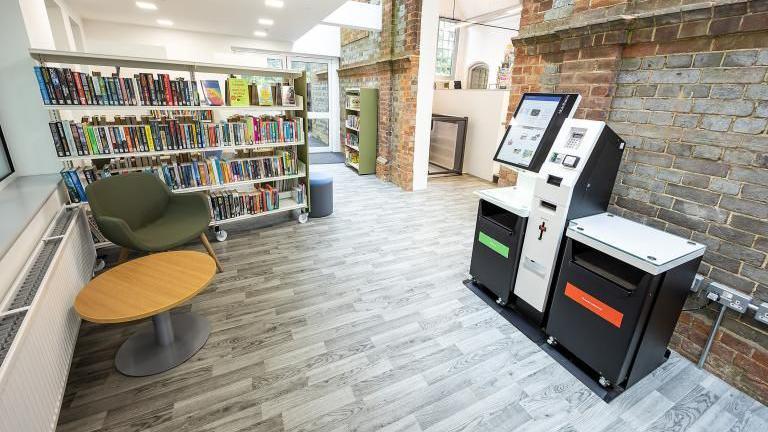 A room in the library with modern wooden floors but exposed brick walls