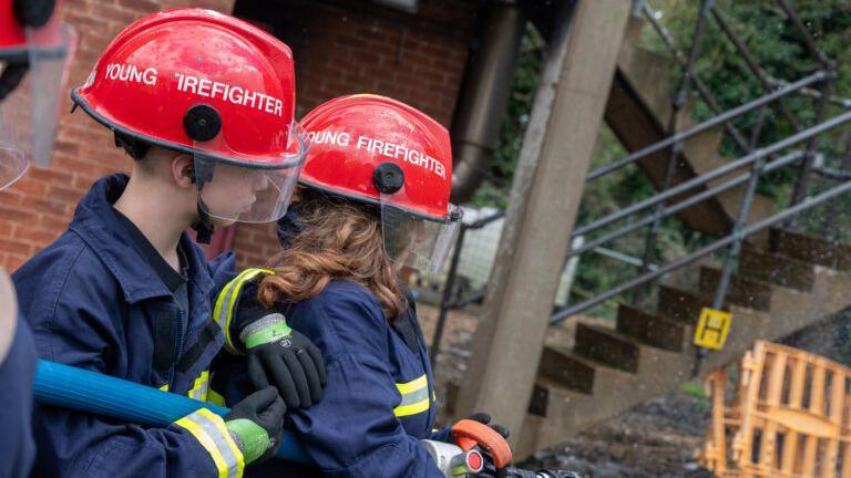 Two children trying out fire skills