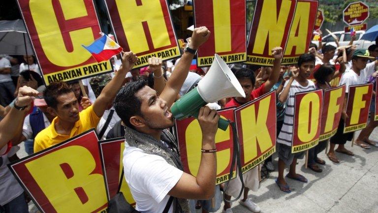 Activists chant and hold placards outside the Chinese embassy in Manila on 11 May 2012