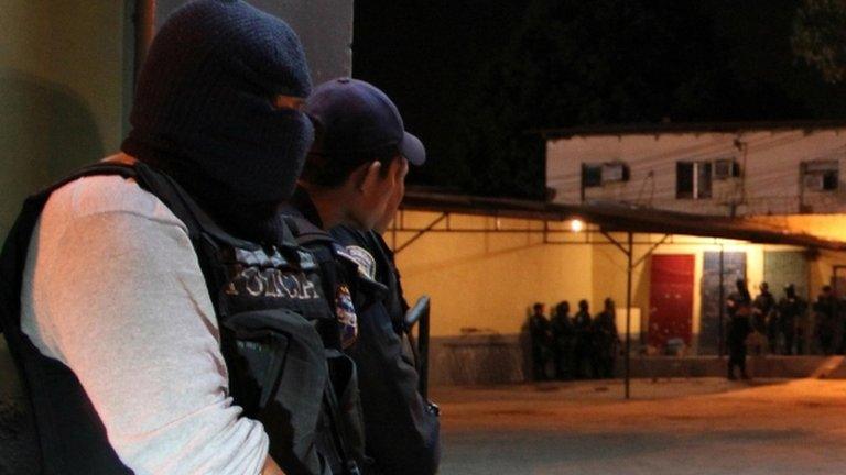 Policemen guard the outside of the prison in San Pedro Sula