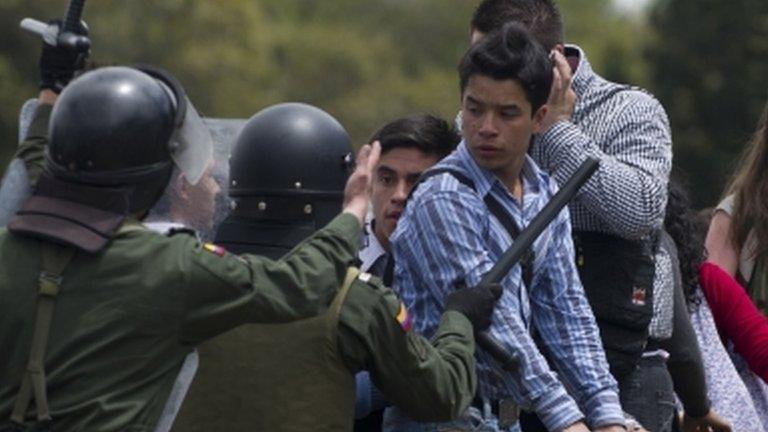 Riot police try to disperse Colombian students protesting against a free-trade deal with the US