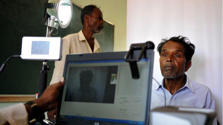 A man being photographed at a biometric booth in India