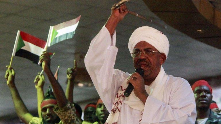 Supporters wave Sudanese flags as Sudan's President Omar al-Bashir addresses supporters during a rally at the ruling party headquarters in Khartoum, 18 April 2012